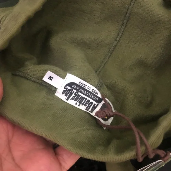 A BATHING APE GREEN 1ST CAMO SWEATS W/ EMBROIDERED LETTERS IN WHITE SZ. M